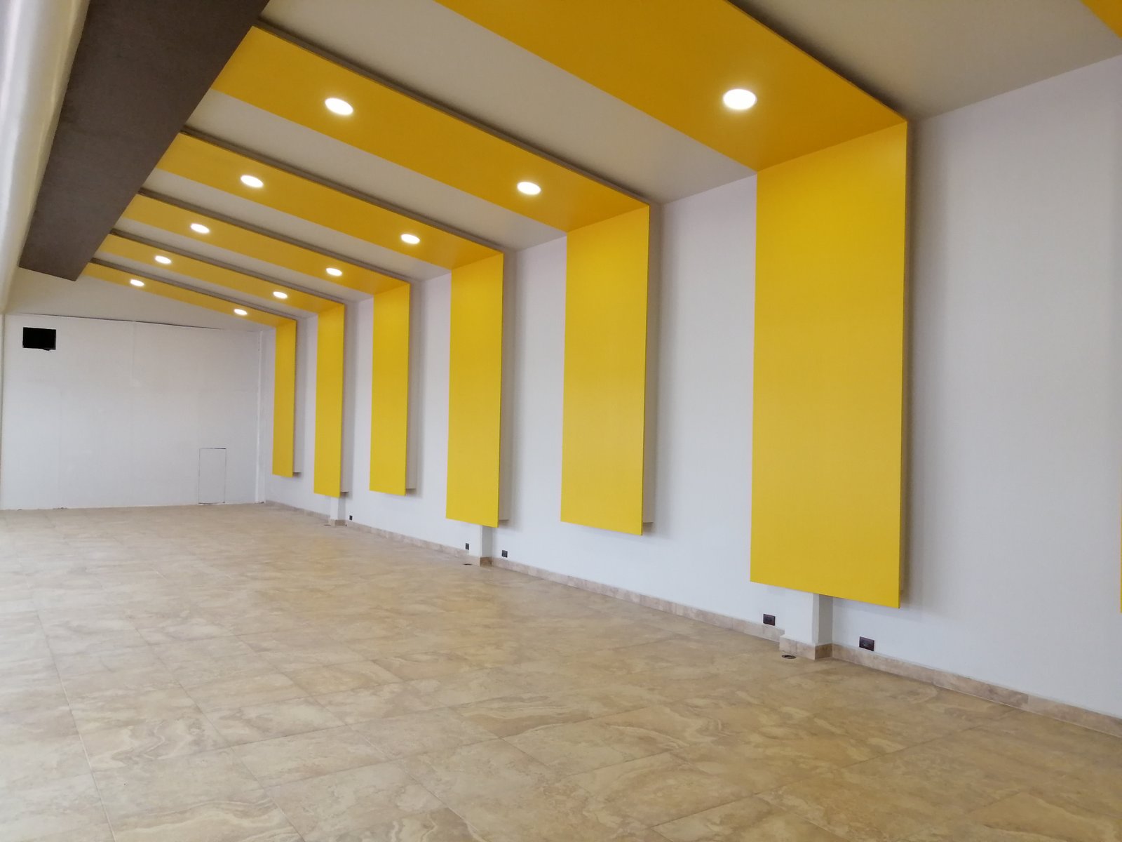 Espacio interior remodelado con plafón geométrico e iluminación empotrada.