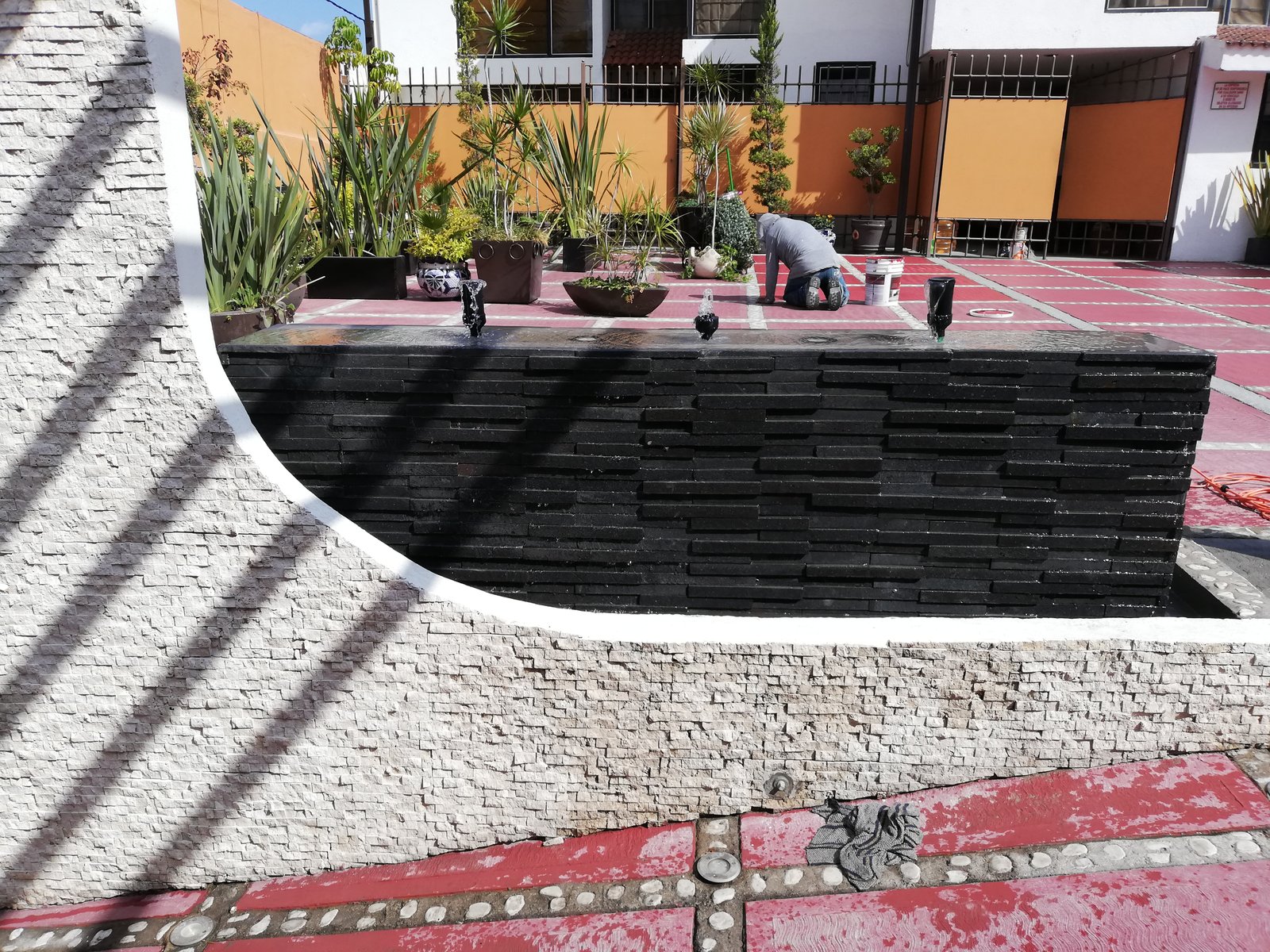 Terraza residencial con jardineras y acabados de piedra.