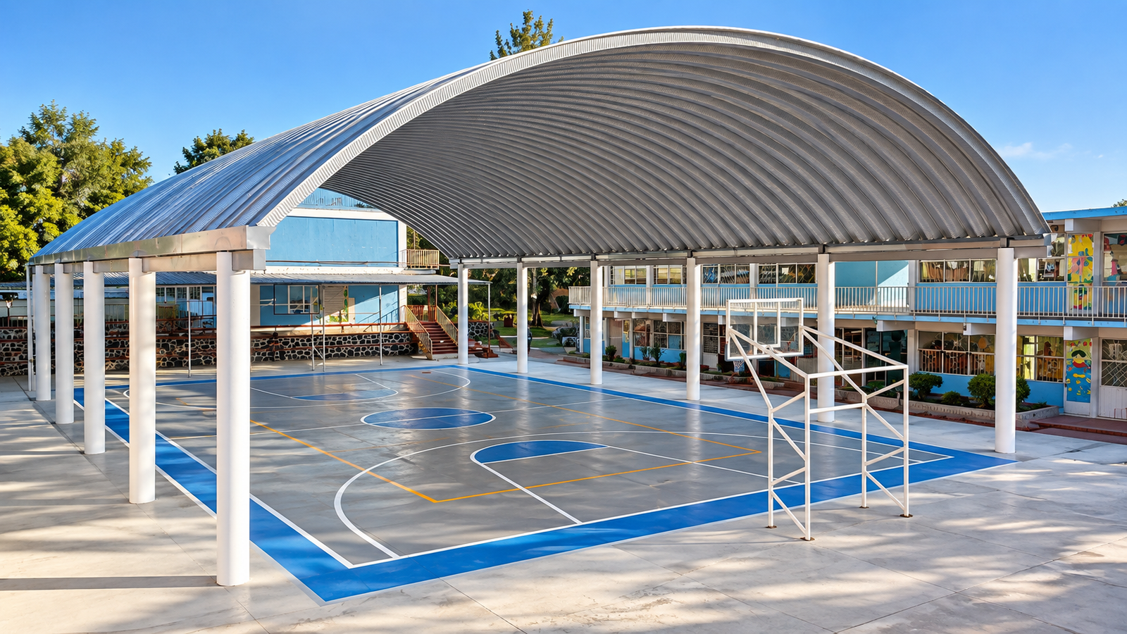 Cancha escolar techada con estructura metálica curva y cancha deportiva azul.